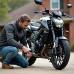 Homme vérifiant la chaîne d'une moto dans une cour résidentielle