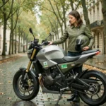 Femme en veste moto verte tenant un casque à côté d'une moto électrique garée sur un boulevard parisien en automne, illustrant l'assurance moto écologique