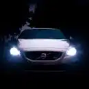 silver Volvo car with headlights on during night